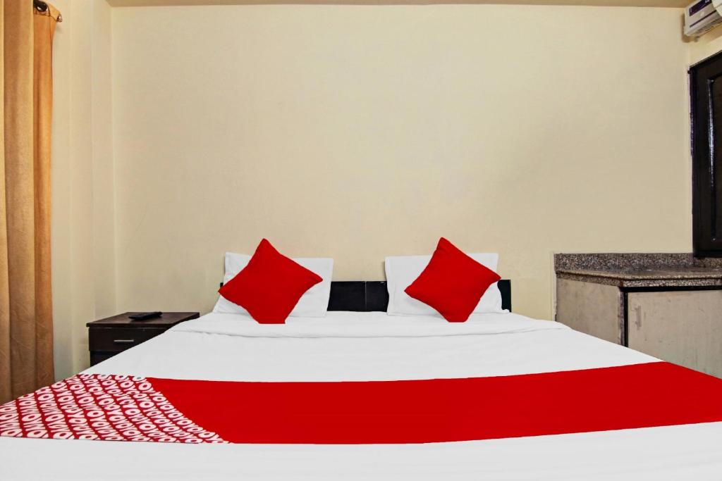 ニューデリーにあるOYO Flagship Hotel B K Palaceのベッドルーム(白いベッド、赤い枕付)