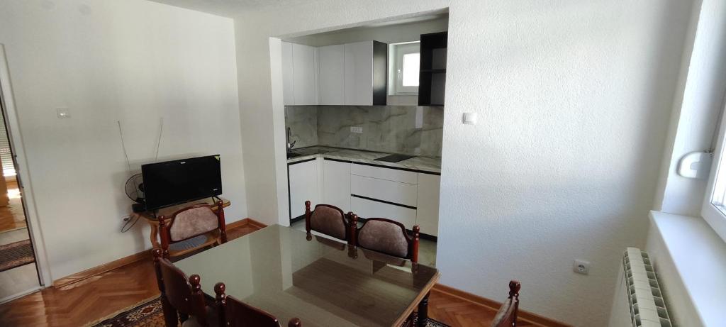 a kitchen with a table and chairs in a room at Home Nikolić in Novi Pazar