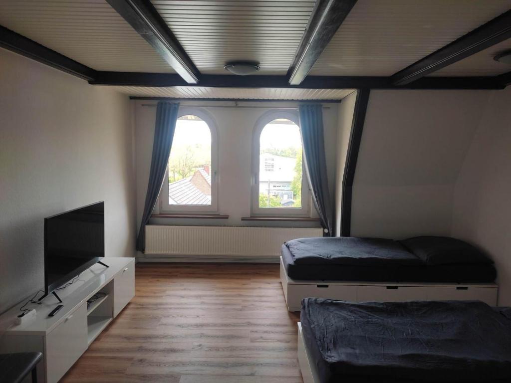 een kamer met 2 bedden, een tv en 2 ramen bij Giraffe-1-4-Personen in Brunsbüttel