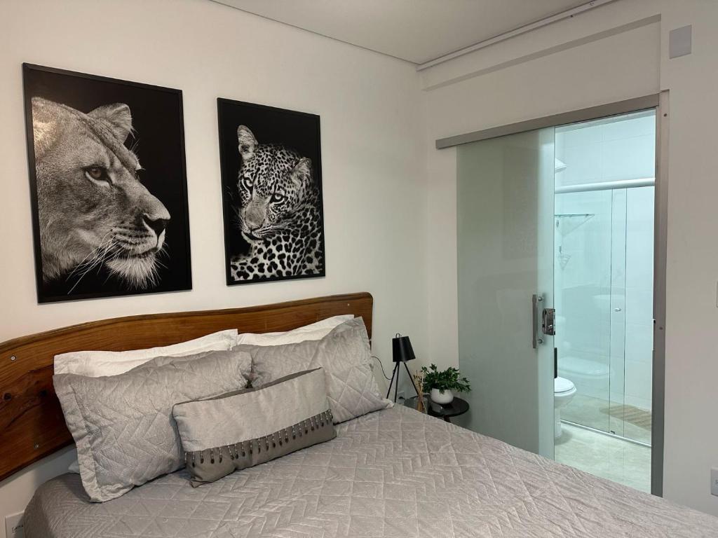 ein Schlafzimmer mit einem Bett mit drei Bildern an der Wand in der Unterkunft Kim Casa BH in Belo Horizonte