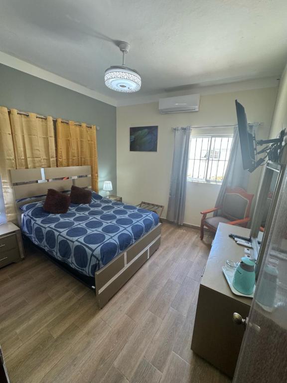a bedroom with a bed with a blue comforter at El Conde De Atrini in Santo Domingo