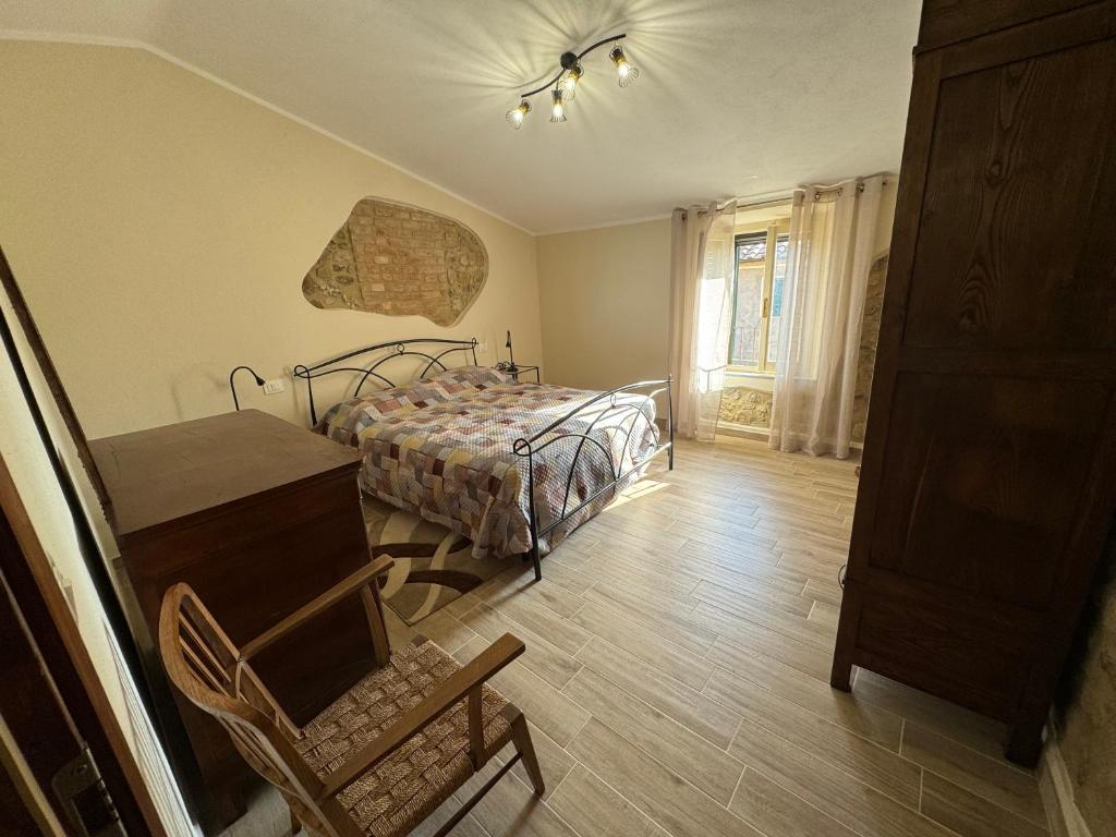 1 dormitorio con cama, escritorio y silla en La Casa dei Nonni, en Sasso dʼOmbrone
