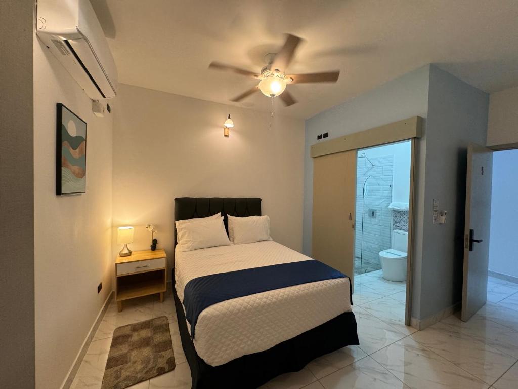 a bedroom with a bed and a ceiling fan at Apartaestudio la capital in San José