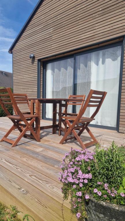 two chairs and a table on a wooden deck at Le Chalet de St Vigor in Saint-Vigor-le-Grand