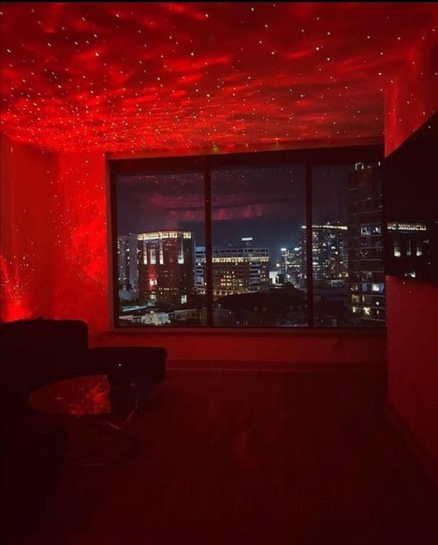 Cette chambre rouge est dotée d'une fenêtre offrant une vue sur la ville. dans l'établissement SpicyGameRoom, à La Paz