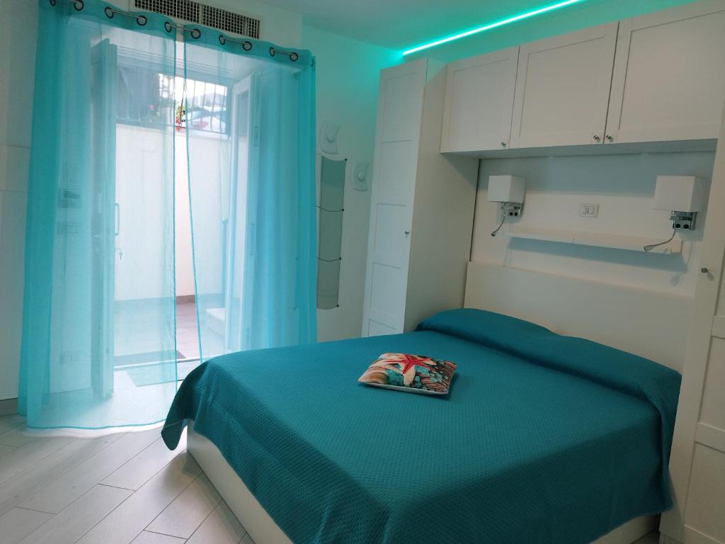 um quarto azul com uma cama com um livro em SoleMare Rooms "Smeraldo" em Procida