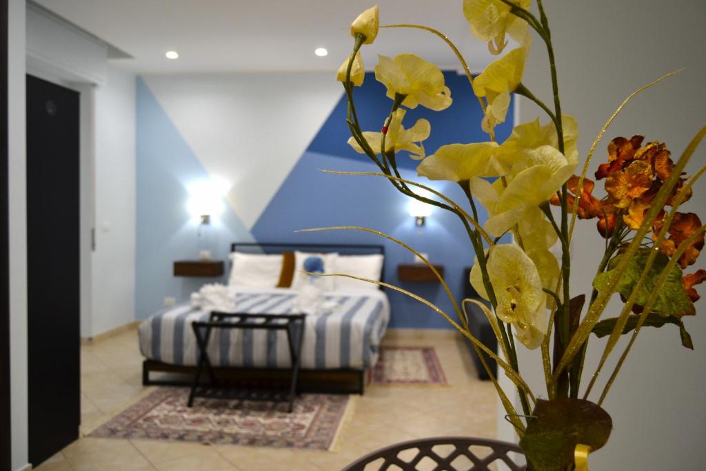 un vaso con fiori in una stanza con un letto di Casa Grazia - Guest House - a Reggio di Calabria