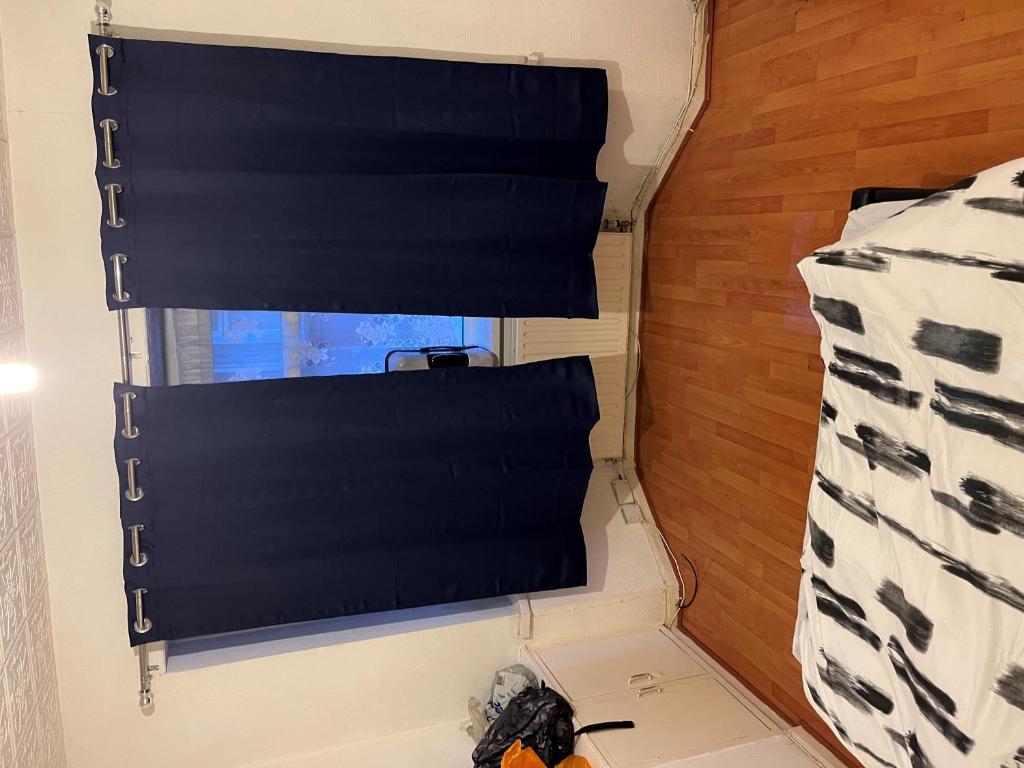 um quarto com uma janela com persianas pretas em Private room close to city centre em Birmingham