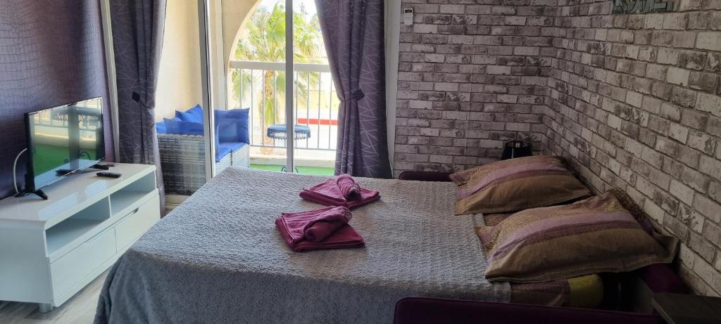 - une chambre dotée d'un lit avec des serviettes violettes dans l'établissement Naturiste Port Soleil, au Cap d'Agde