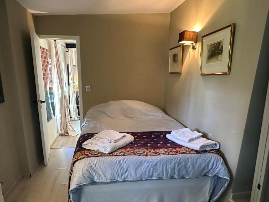 a small bedroom with a bed with towels on it at Central Valbonne Villa in Valbonne