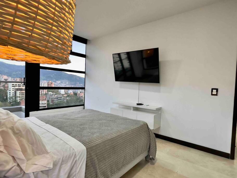 - une chambre avec un lit et une télévision à écran plat dans l'établissement 2001 Charming apartment in El Poblado, à Medellín