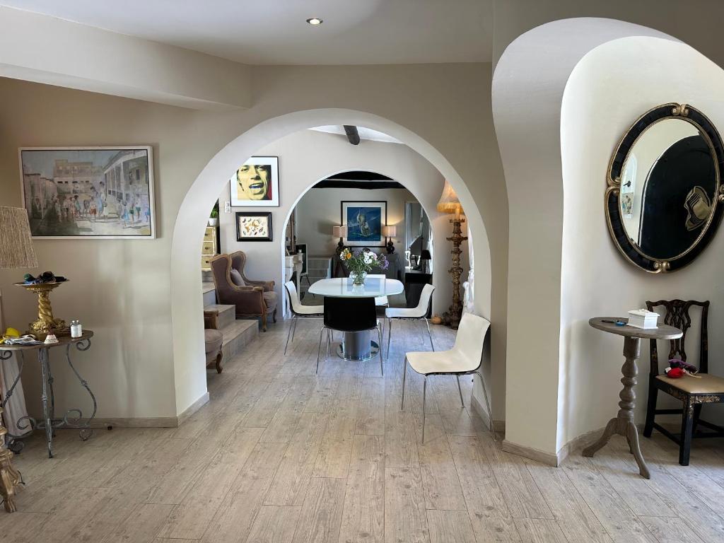 a living room with an archway with a table and chairs at Central Valbonne Villa in Valbonne