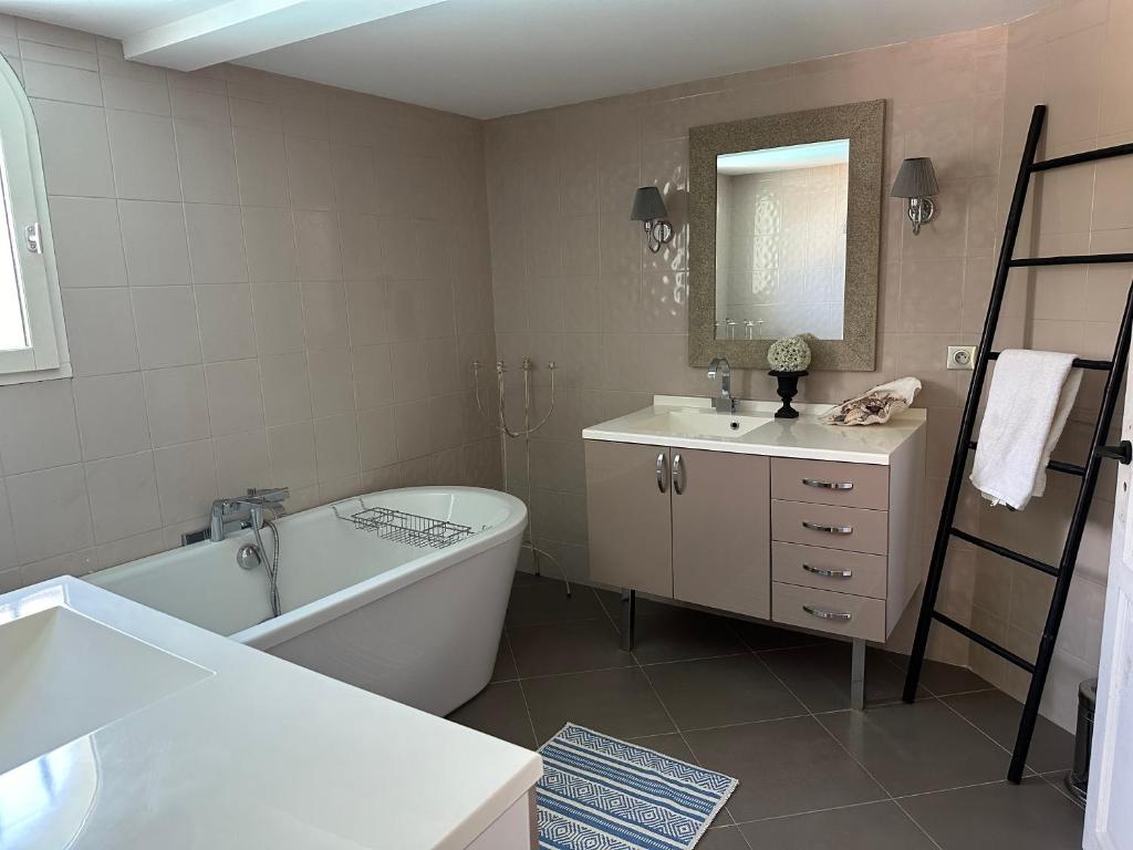 a bathroom with a tub and a sink and a bath tub at Central Valbonne Villa in Valbonne