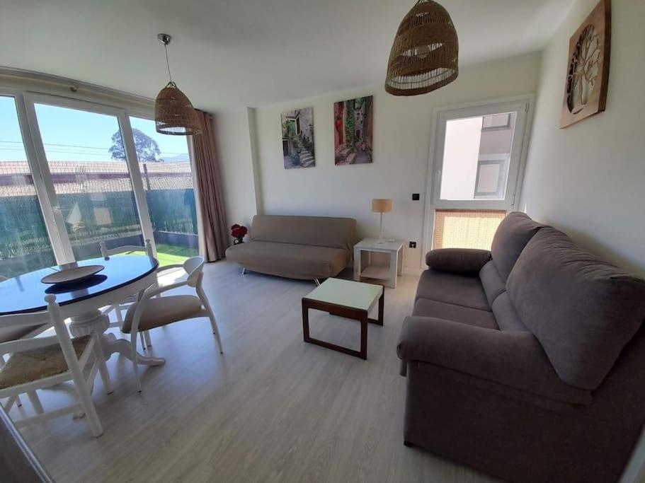 uma sala de estar com um sofá e uma mesa em Apartamento con terraza a 2,5km de las playas em Posada de Llanes