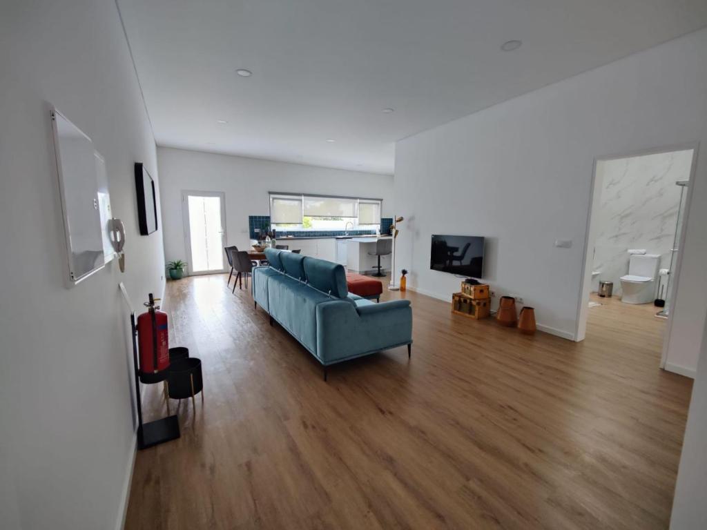 ein Wohnzimmer mit einem blauen Sofa und einem Tisch in der Unterkunft Xª Deluxe Apartments in Ribeira Grande