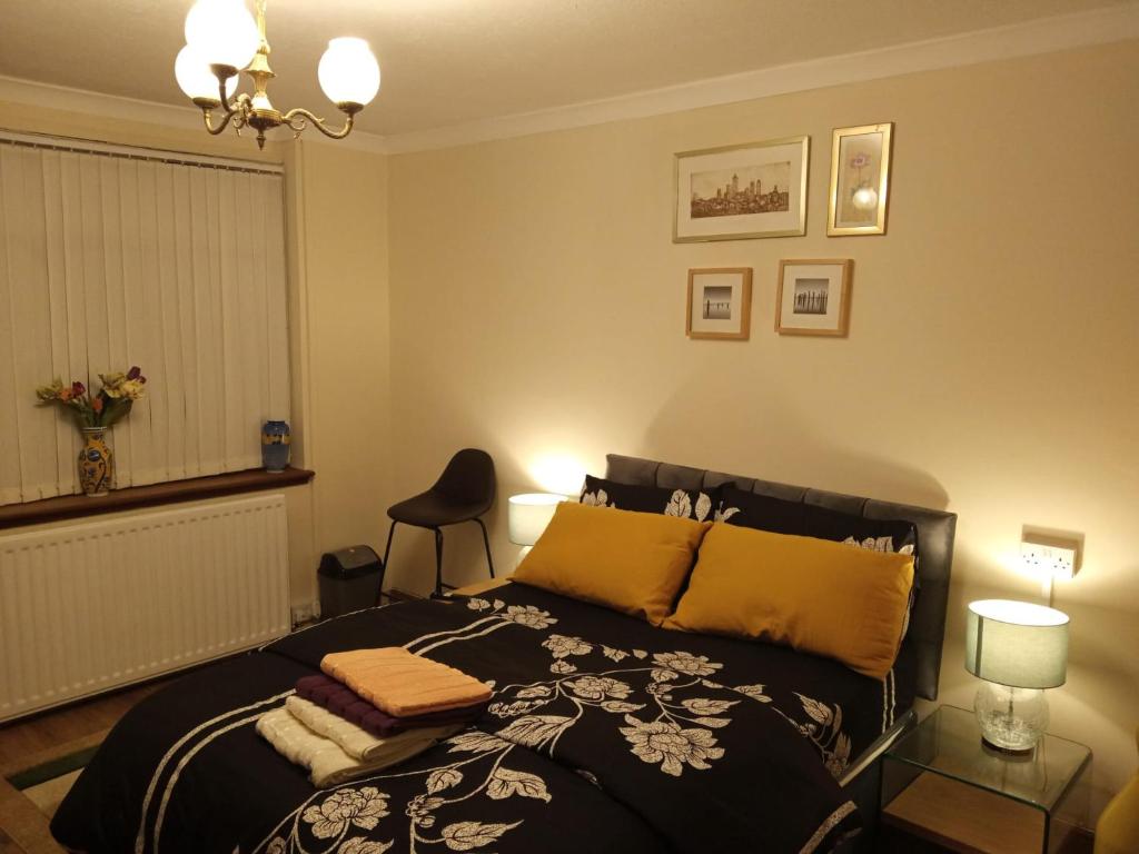 1 dormitorio con cama negra y almohadas amarillas en Inviting 3-Bed Apartment in Walsall en Walsall