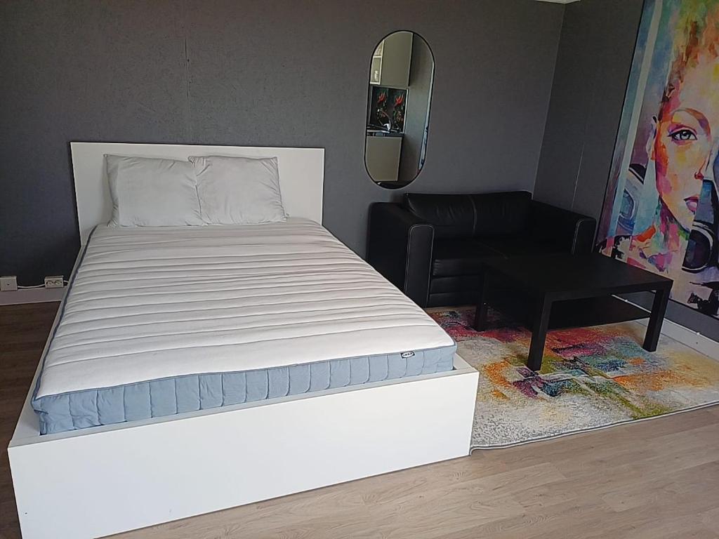 a white bed in a room with a mirror at Klinta sea view 2 in Köpingsvik