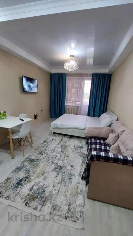 1 dormitorio con cama, sofá y mesa en Apartment, en Astana