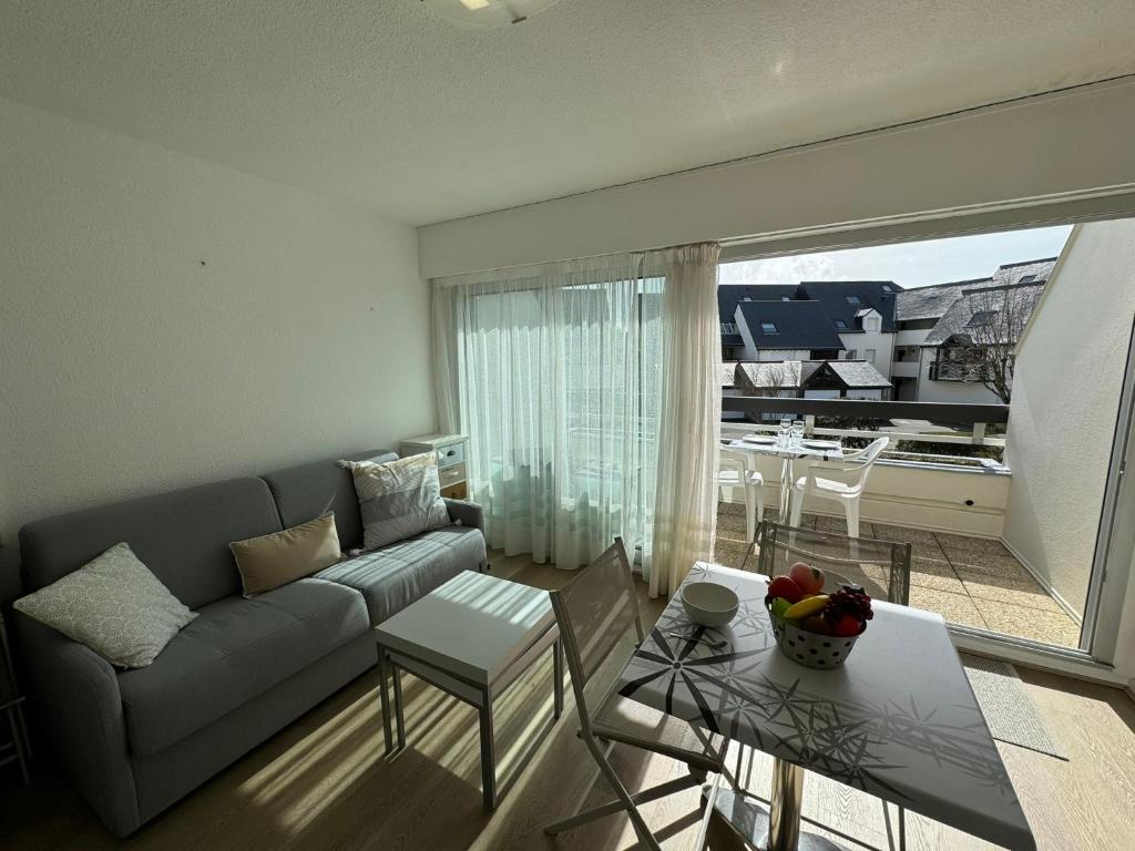un soggiorno con un divano e un tavolo di Confortable studio, wifi, parking, proche plage a Carnac
