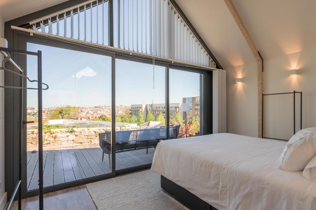 Schlafzimmer mit einem Bett und einem großen Glasfenster in der Unterkunft FONTE SANTA Manor House in Vila Nova de Gaia