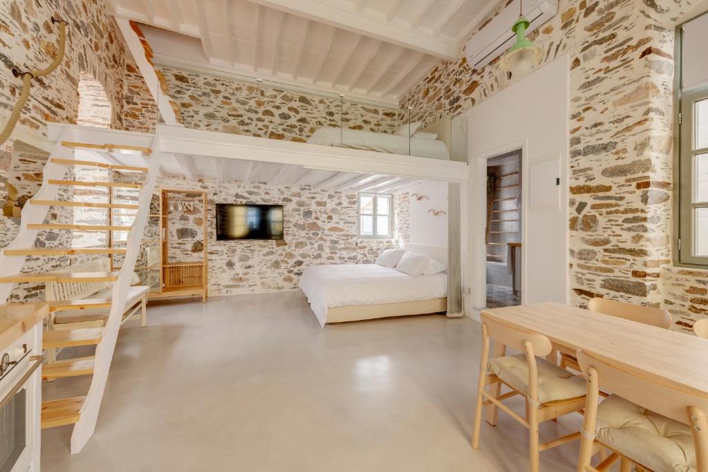 um quarto com uma cama, uma mesa e cadeiras em ArtdecoSyros Superior em Ano Syros
