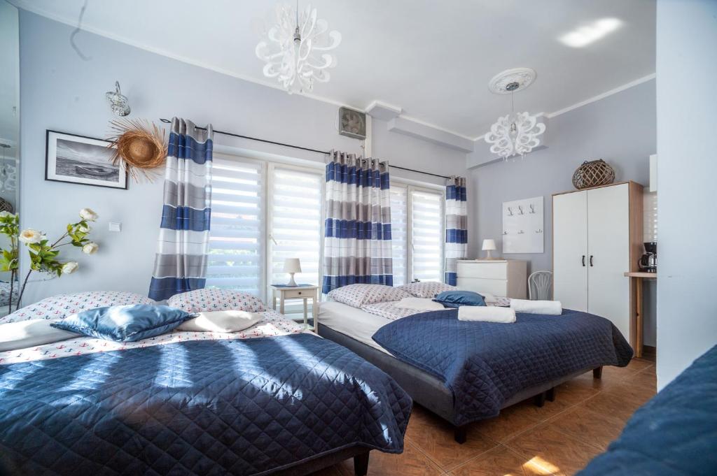 1 dormitorio con 2 camas y ventana en Willa Morski Klimat en Łeba