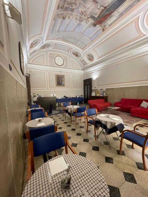 Habitación con mesas, sillas y techo. en Dante Rooms, en Nápoles