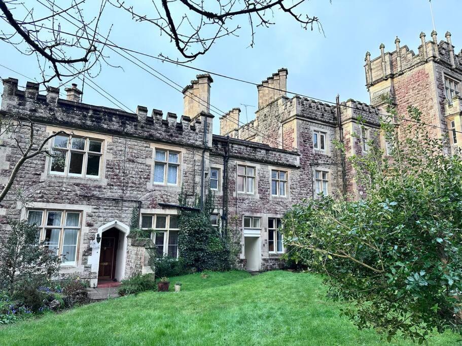 an old castle with a green lawn in front of it at Unique apartment in stunning Manor house in Potterne