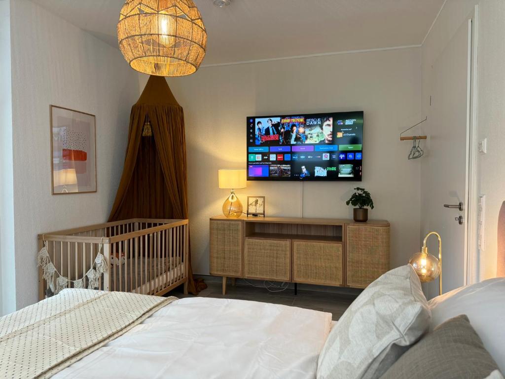 a bedroom with a crib and a flat screen tv at Familienurlaub im Schwarzwald, Europapark-Nähe in Ettenheim