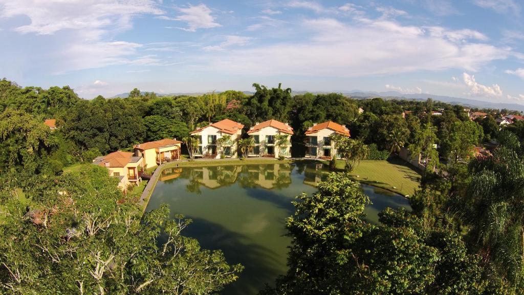 an aerial view of a house with a large pond at Pousada do Lago Penedo in Penedo