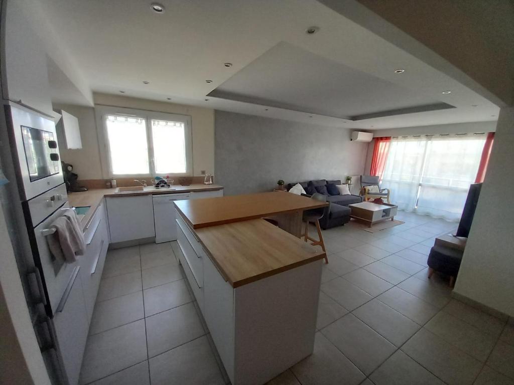 cocina y sala de estar con mesa y sofá en Appartement 1er étage, 66 m² en La Seyne-sur-Mer