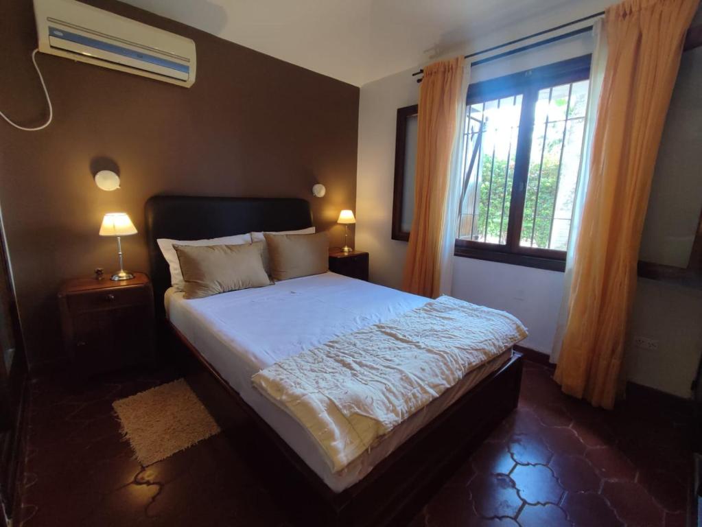 a bedroom with a large bed with a window at Chalet Del Lago in Termas de Río Hondo