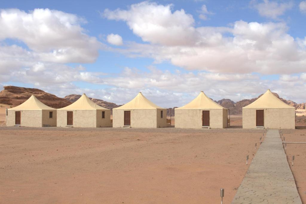 rząd namiotów na pustyni pod pochmurnym niebem w obiekcie Remal Wadi Rum Camp & Tour w mieście Disah