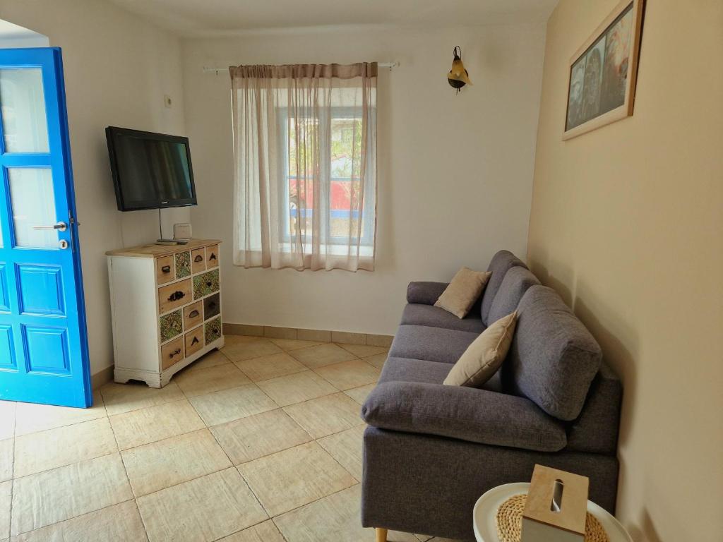 a living room with a couch and a television at Kazanegra Exclusive Apartments in Sveti Stefan