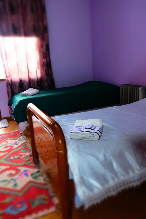 1 dormitorio con 1 cama con manta azul y ventana en Kroi'Pistolve, en Krujë