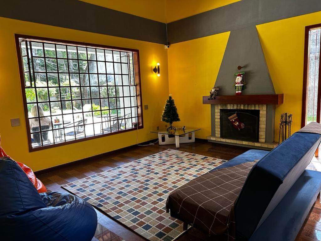 a living room with a couch and a fireplace at Village Hostel in Petrópolis