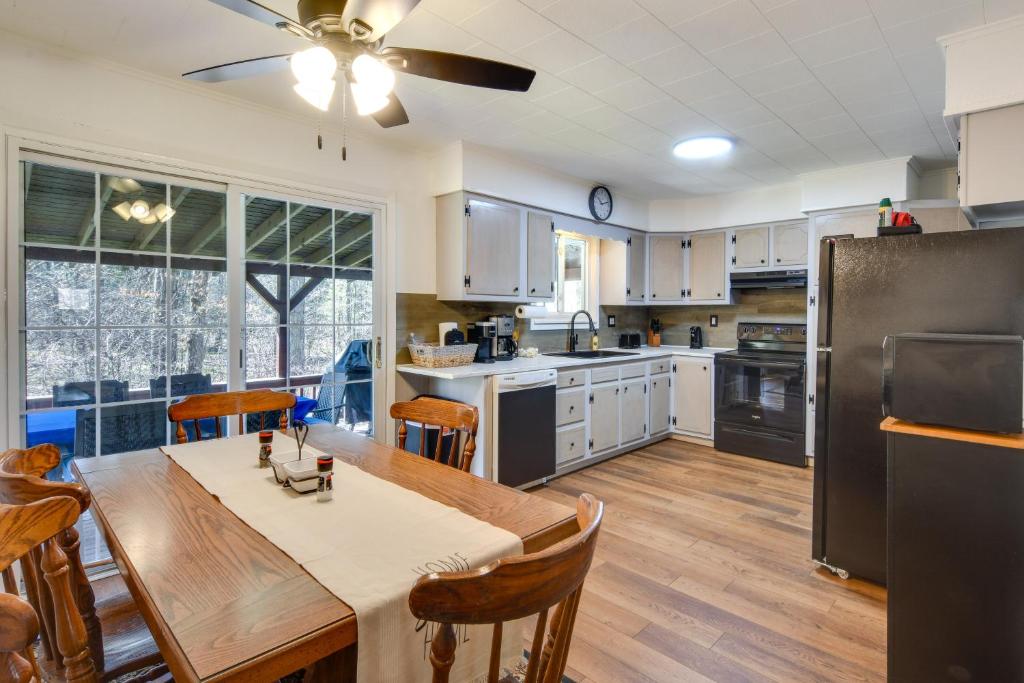 a kitchen with a table and chairs and a refrigerator at Cozy DuBois Home with Deck about 8 Mi to Treasure Lake! in DuBois