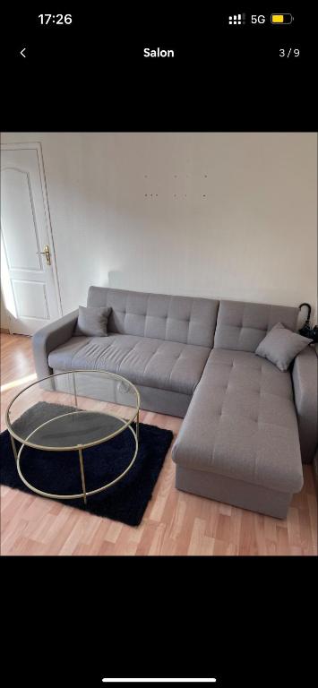 un salon avec un canapé et une table en verre dans l'établissement Logement entier F2 Stade de France, à Saint-Denis