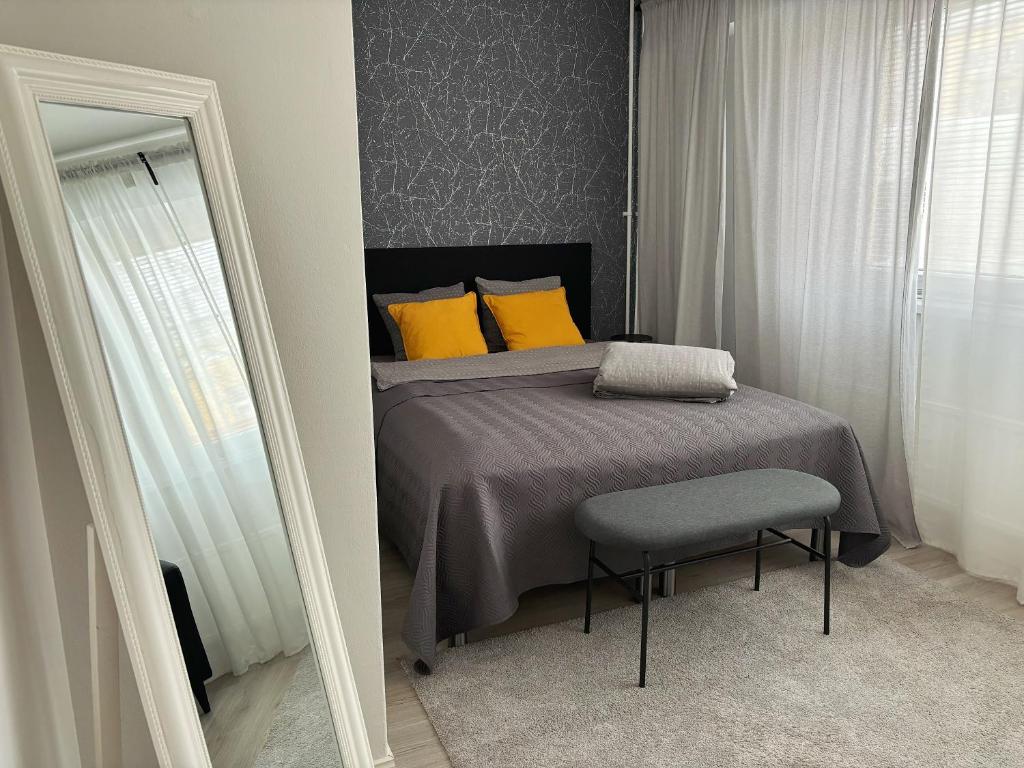 Un dormitorio con una cama con almohadas amarillas y una silla en Hamina City Apartments en Hamina