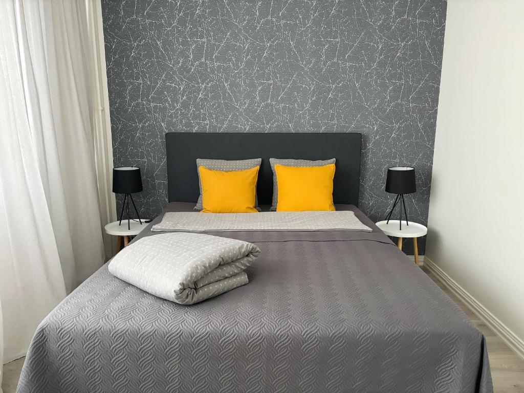 1 dormitorio con 1 cama con 2 almohadas amarillas en Hamina City Apartments, en Hamina