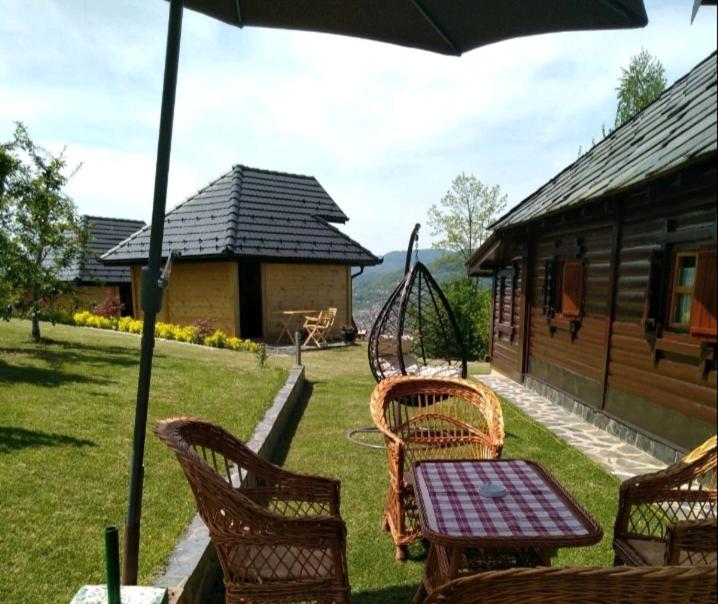 eine Terrasse mit einem Tisch, Stühlen und einer Schaukel in der Unterkunft Apartmani Suncevica in Arilje
