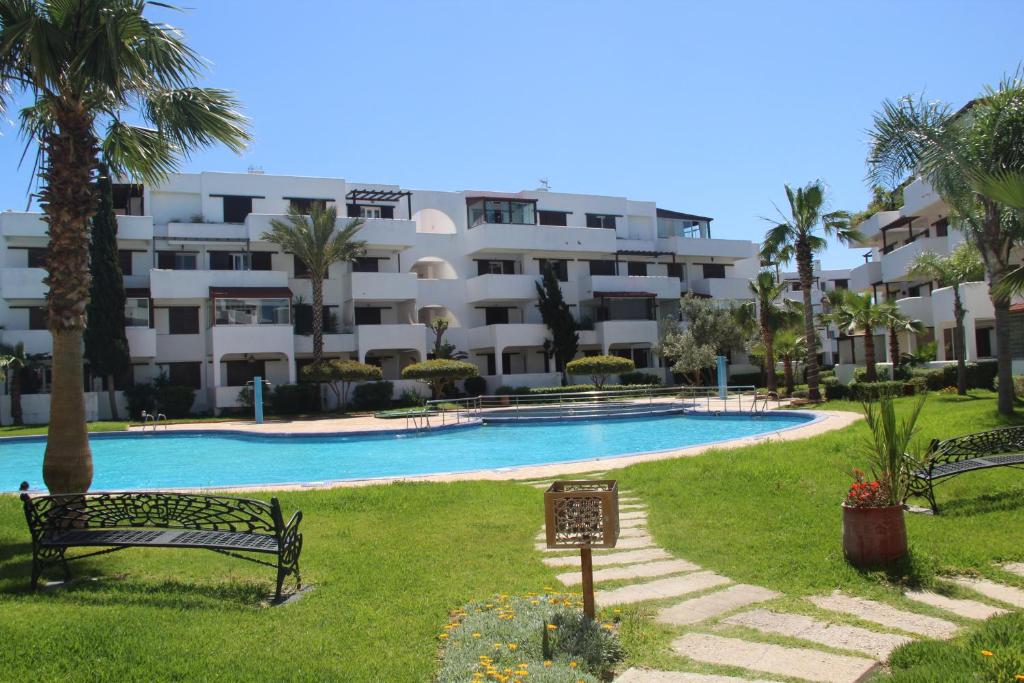 uma piscina em frente a um grande edifício em Best Apartment La Cassia Beach & Golf Resort, Cabo Negro em Cabo Negro