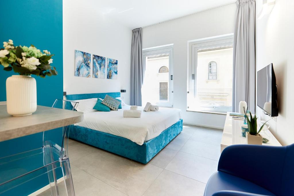 1 dormitorio azul y blanco con 1 cama y TV en Suite Meravigli - Incredibile posizione DUOMO e CASTELLO, en Milán