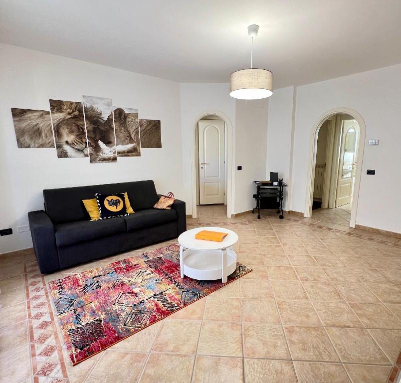 a living room with a black couch and a rug at LA Home - Animal House in Viareggio