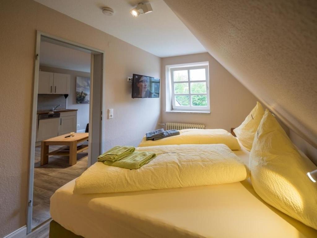 two beds in a room with yellow sheets at Arche Svea Kiebitz in Spiekeroog