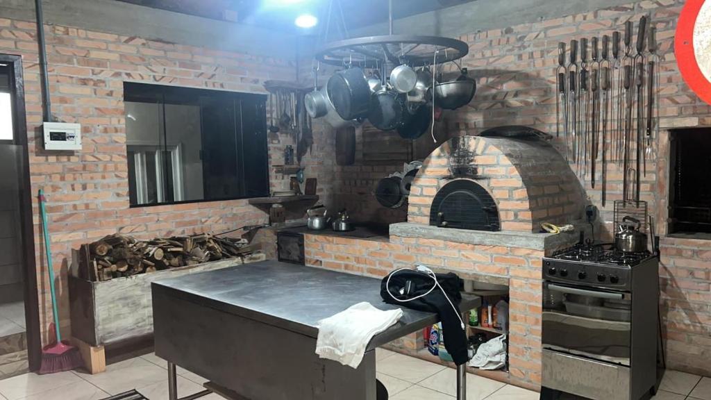 cocina con pared de ladrillo y horno en Sitio Bonanza, en Guaratuba