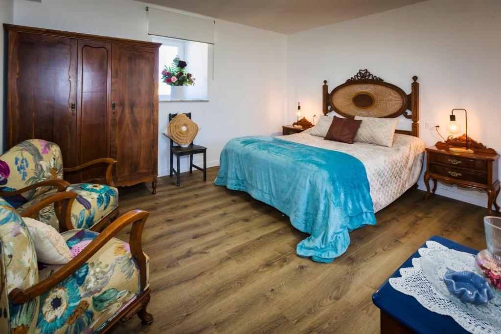 um quarto com uma cama grande e uma cadeira em Casa Lela Dumbria em Dumbría