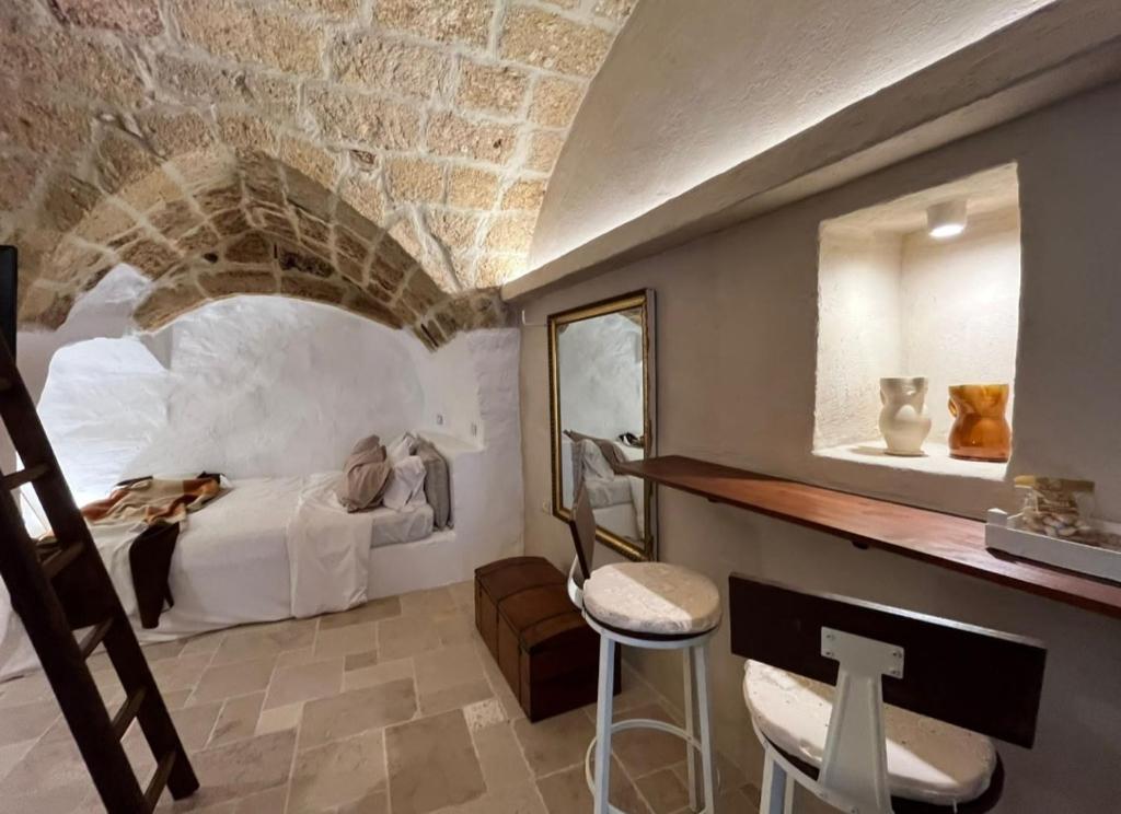 ein Schlafzimmer mit einem Bett und einer Steinmauer in der Unterkunft La Segreta del Castello Self Check-in, private access in Gioia del Colle