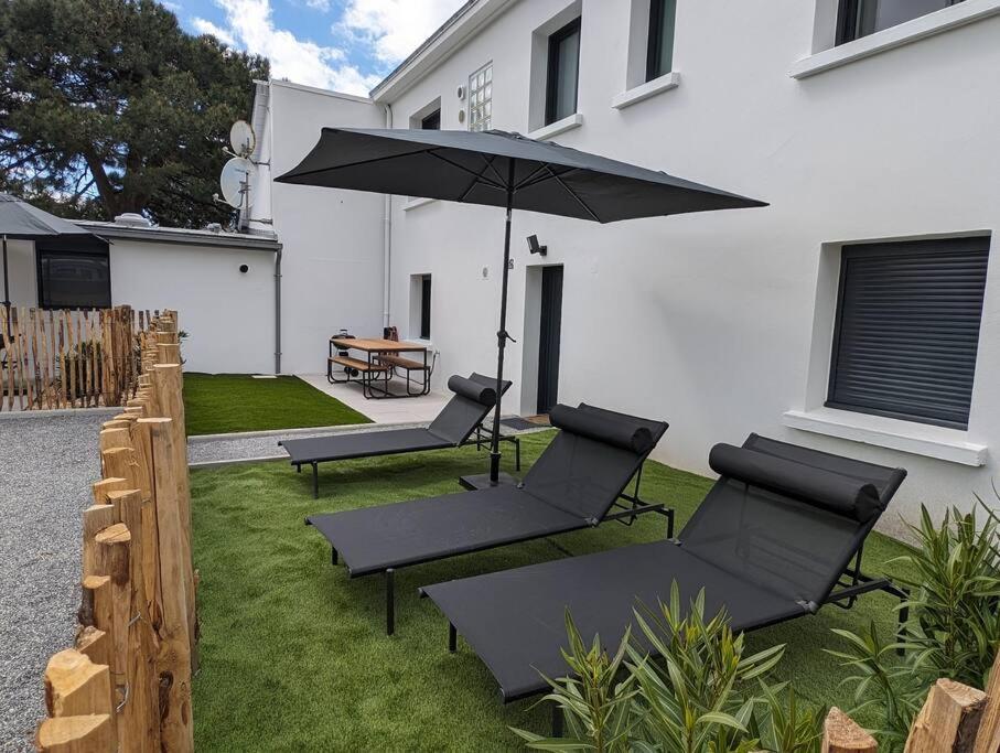 a patio with two chairs and an umbrella at 500 m de la plage - Terrasse - 3 chambres in Piriac-sur-Mer
