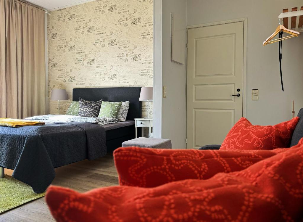 a bedroom with a bed and a couch and chairs at Hamina Bastion Apartments in Hamina